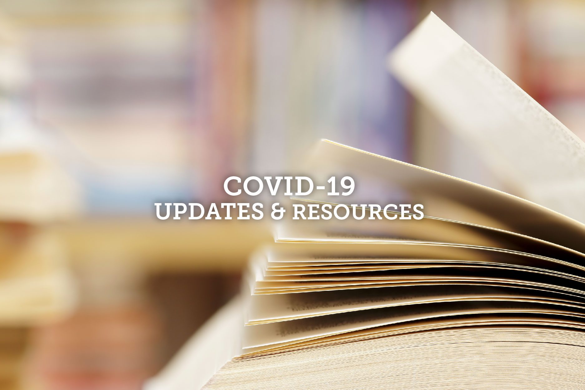 Open book with pages fanned out, overlaid with "COVID-19 UPDATES & RESOURCES".