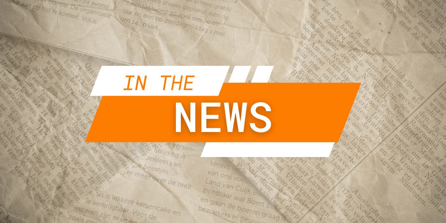 Orange and white graphic with "IN THE NEWS" over newspaper.