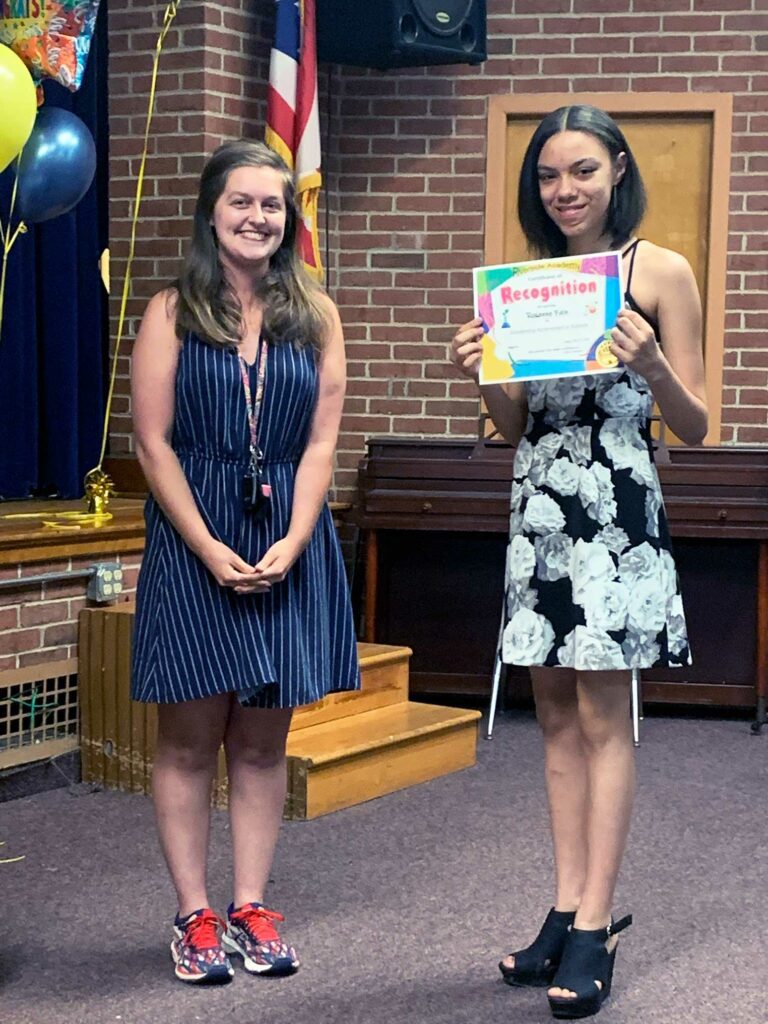 Adult and child with a colorful "Recognition" certificate.
