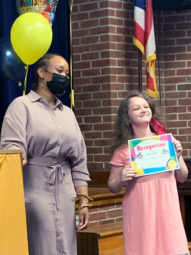 Adult and child with recognition certificate.