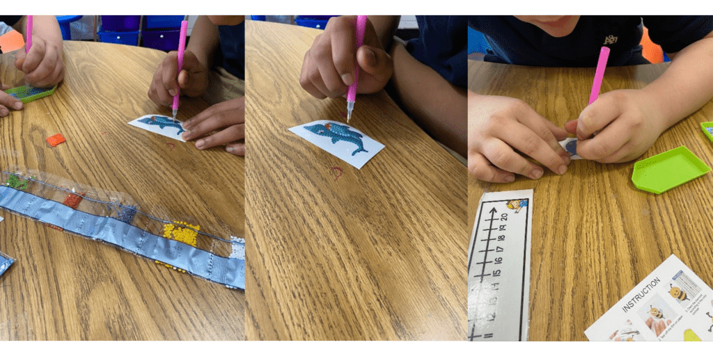Children applying beads to dolphin stickers with pink tools.