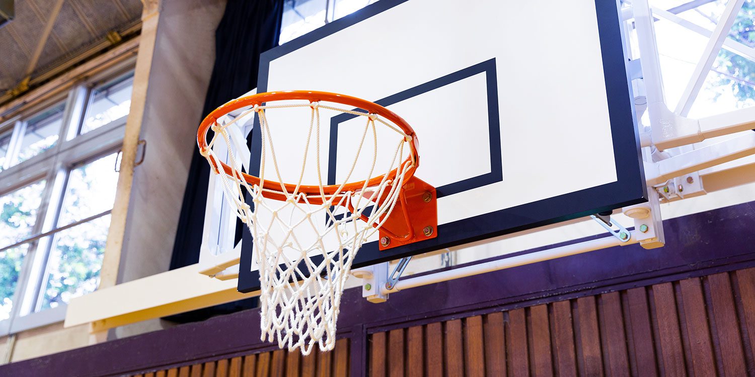 Basketball hoop with orange rim, white net, and white backboard.