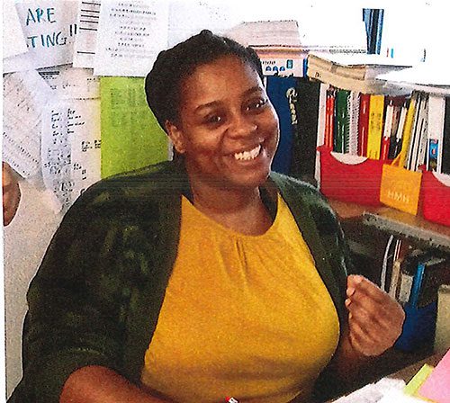 Smiling adult at a desk.