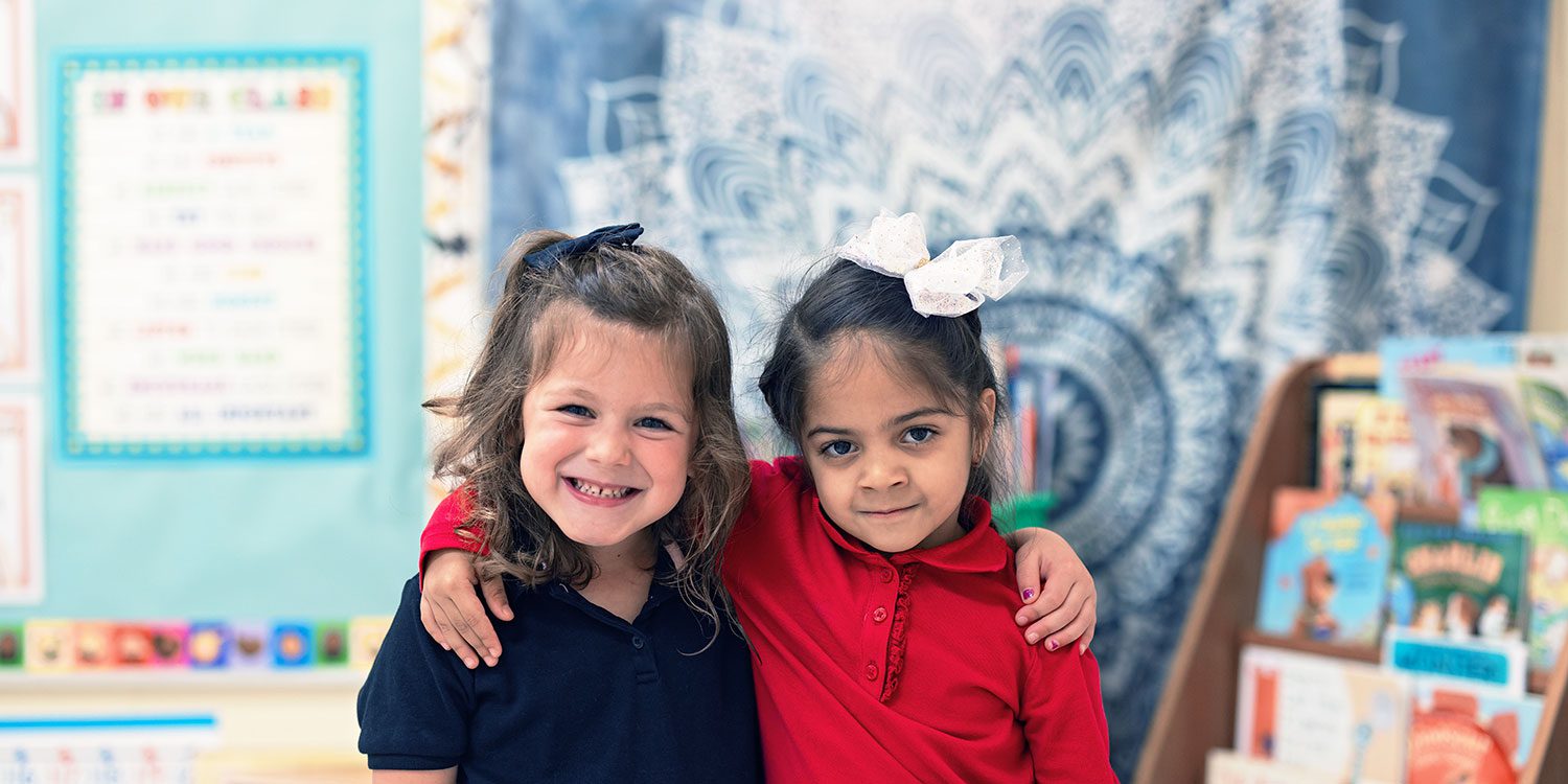 Two smiling children in a classroom.