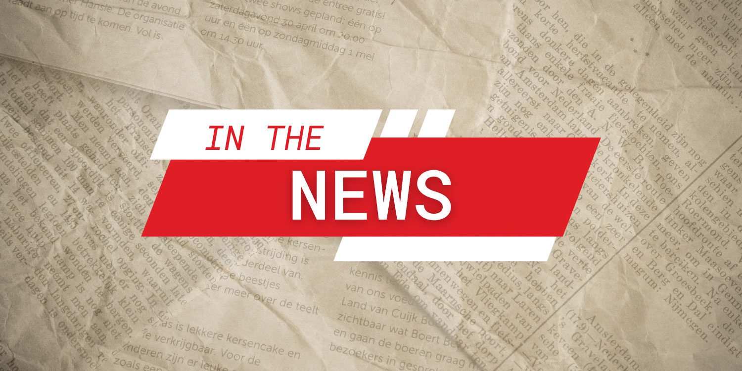 Red and white graphic "IN THE NEWS" on newspaper.