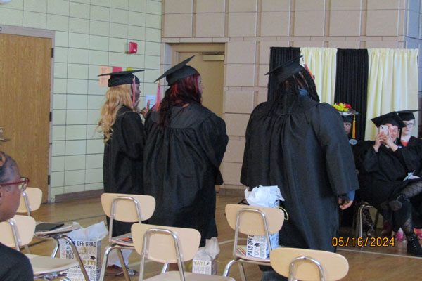 Adults in black graduation caps and gowns.