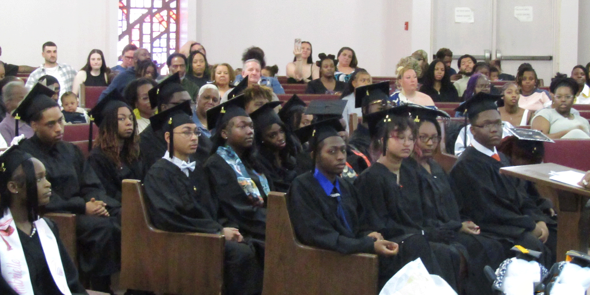 Graduates and guests seated in an auditorium.