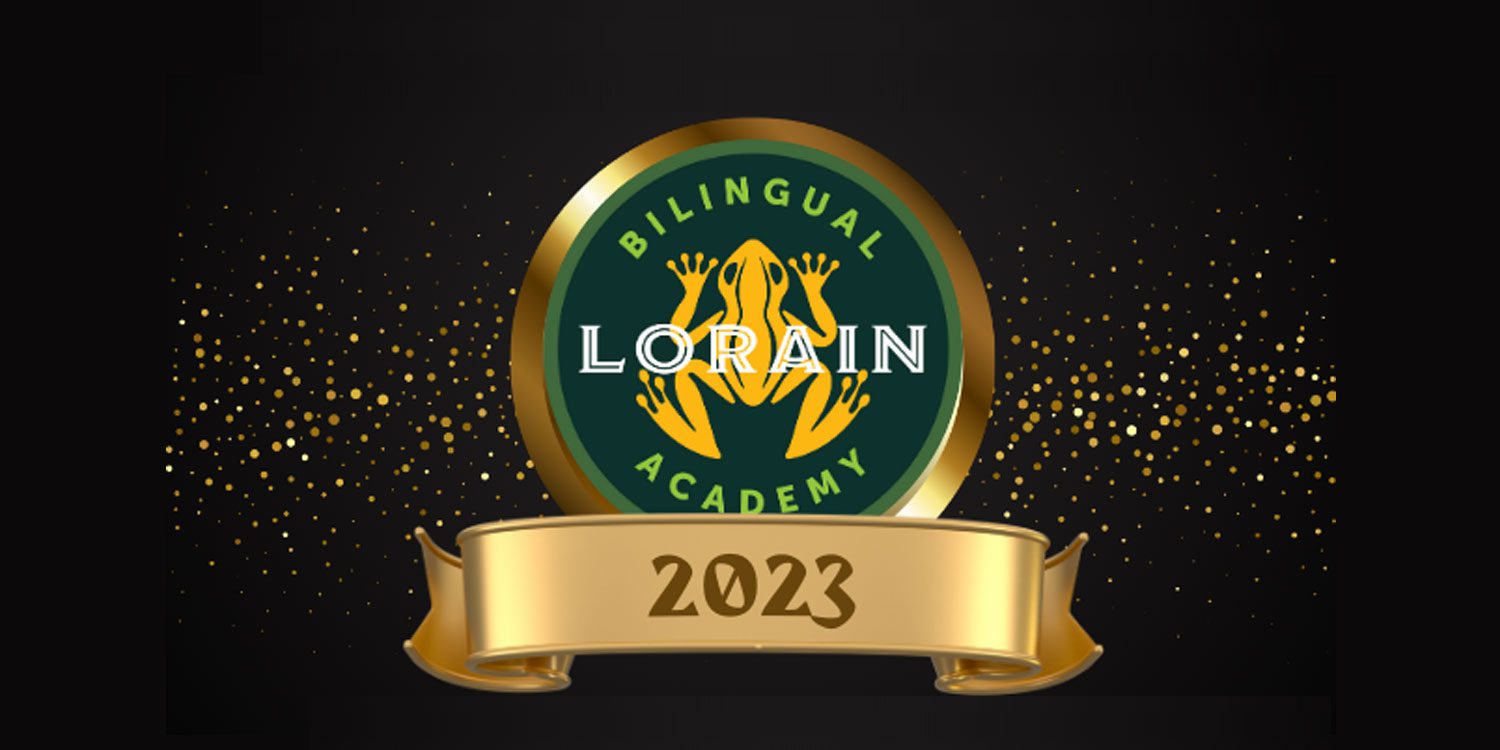 Bilingual Lorain Academy logo with a frog and the year 2023.