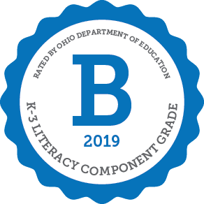 Seal with a large 'B' for K-3 literacy component grade.