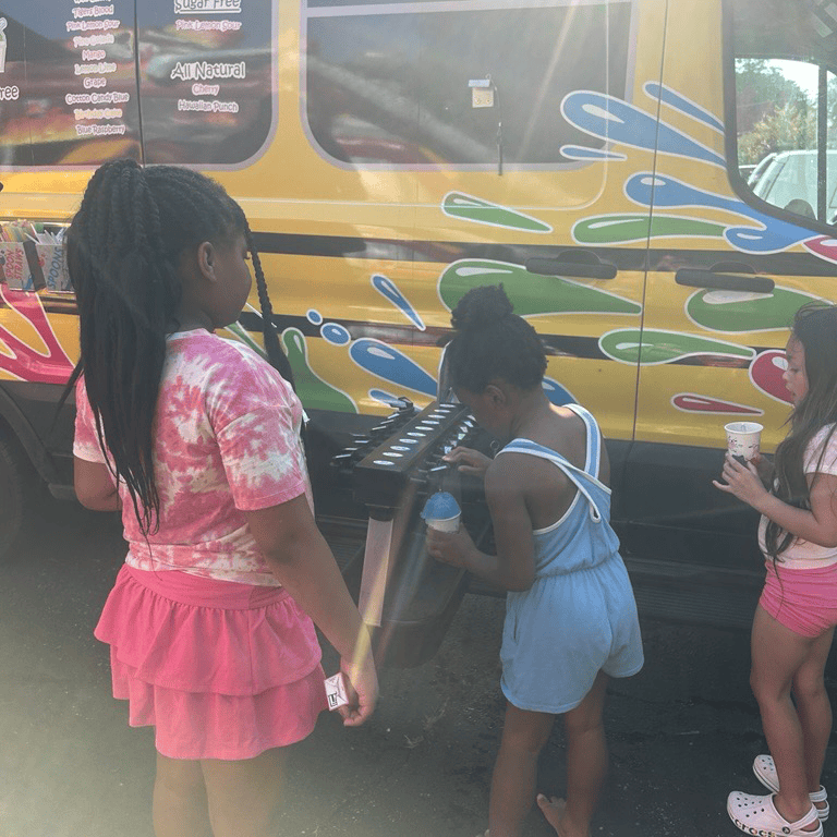 Children getting drinks from a yellow food truck.