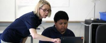 Adult and child looking at a laptop screen together.