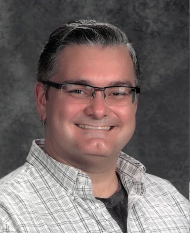 Smiling adult with glasses.