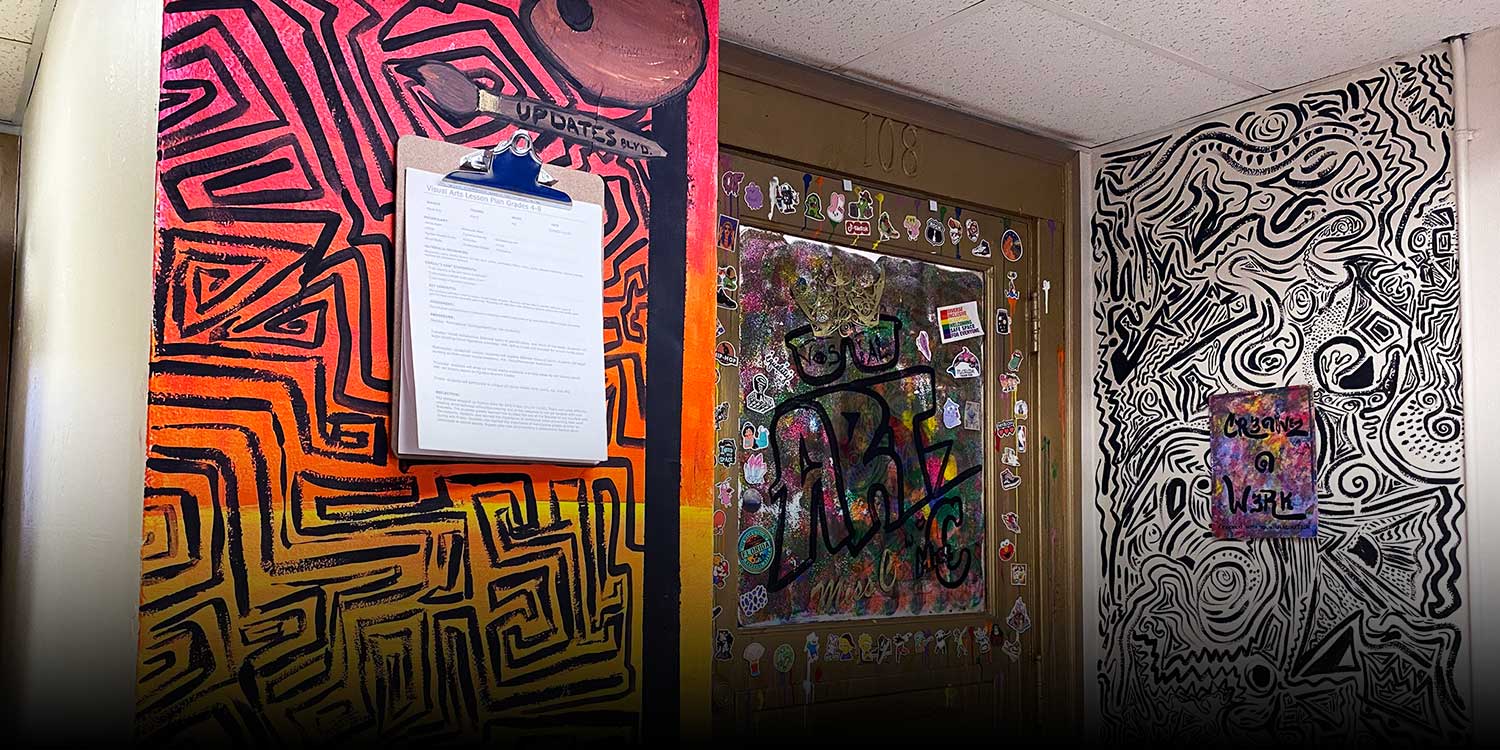 Hallway with a decorated door, colorful murals, and a clipboard.