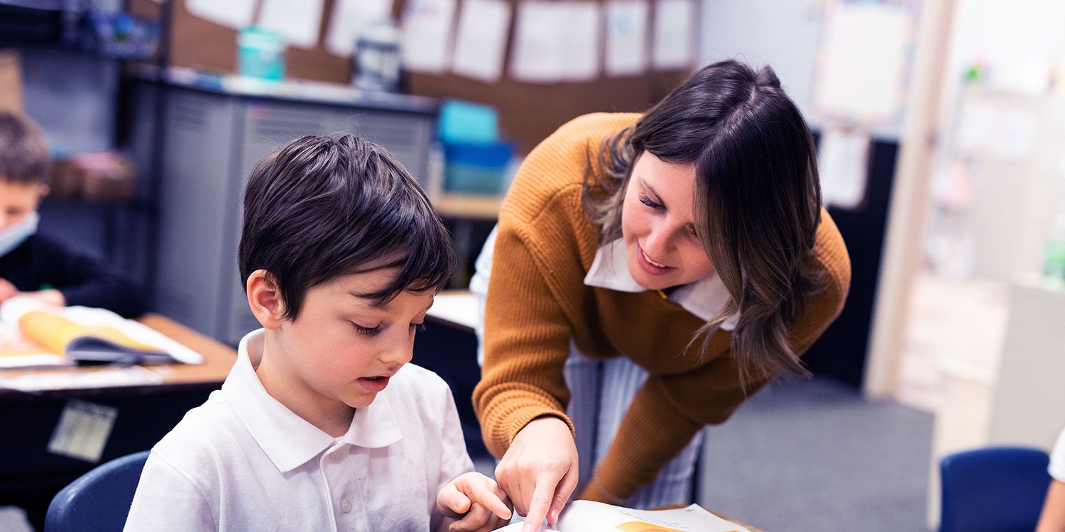 Adult and child reading a book together.