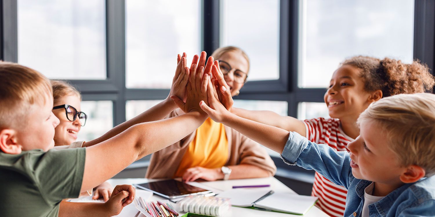 Adult and children high-fiving, smiling.