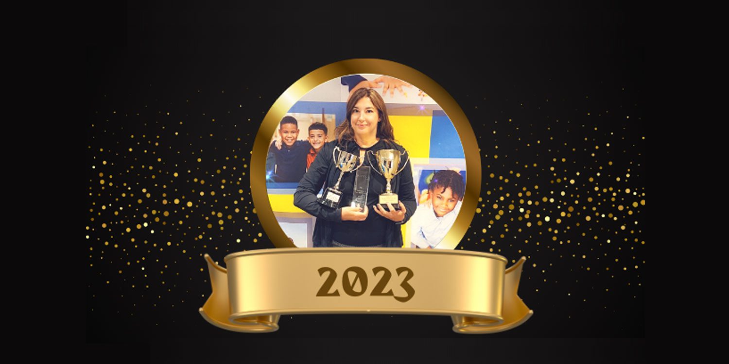 Adult holding trophies with children in background, gold confetti, and "2023" banner.