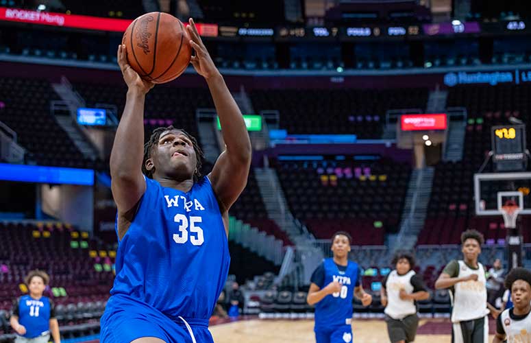 Adult in blue jersey shooting a basketball.