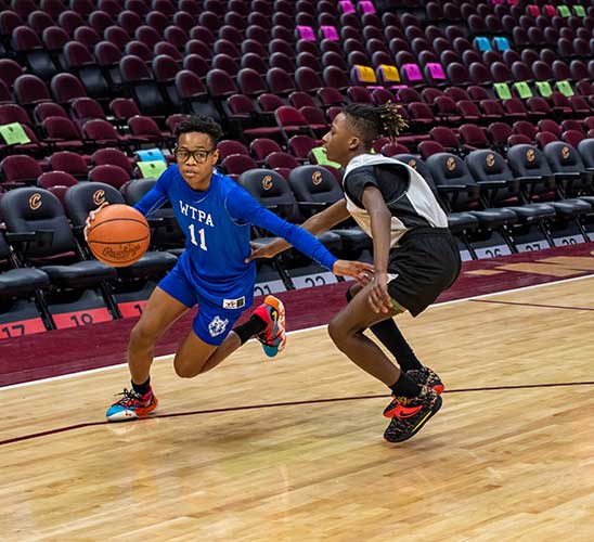 Two children playing basketball on a court.